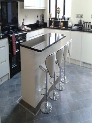 karndean installed in a kitchen with an island laid on the 45° with feature stripping and a mosaic border